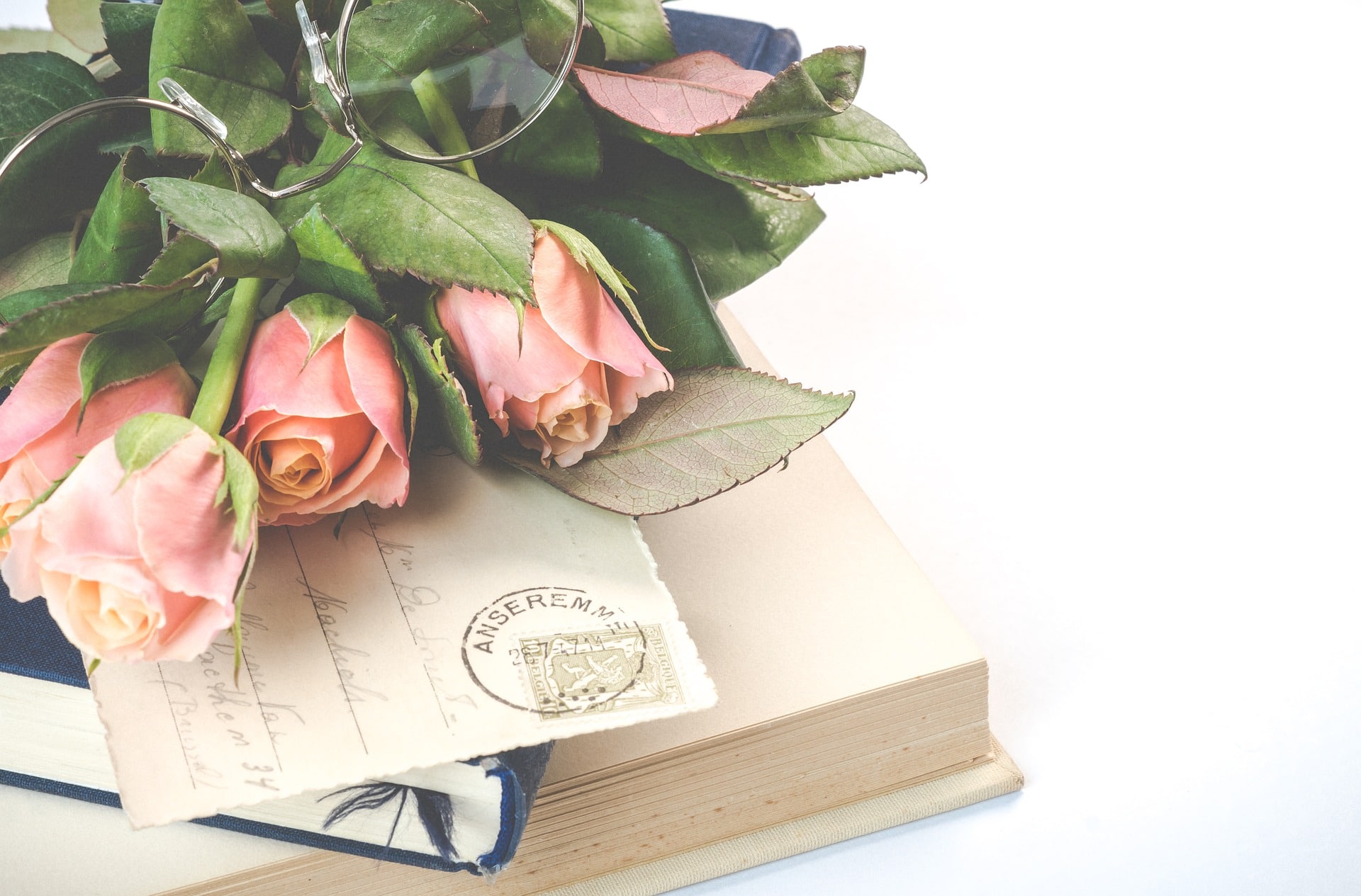 roze rozen bril bovenop kaartje en boeken