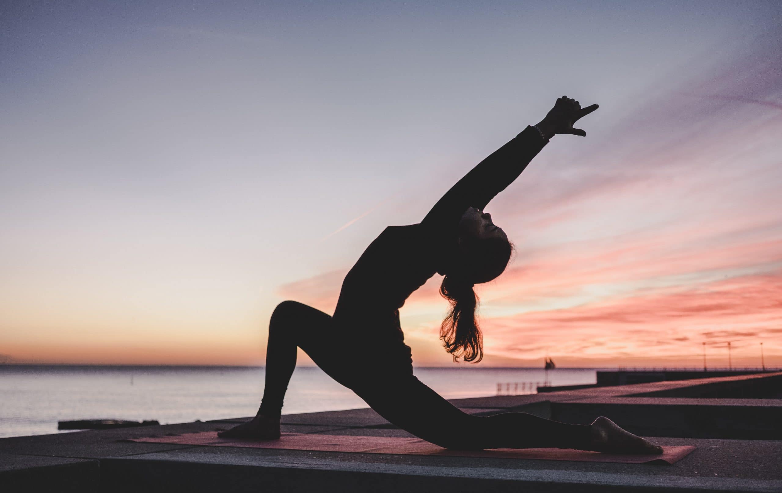 Vrouw yoga zonsondergang
