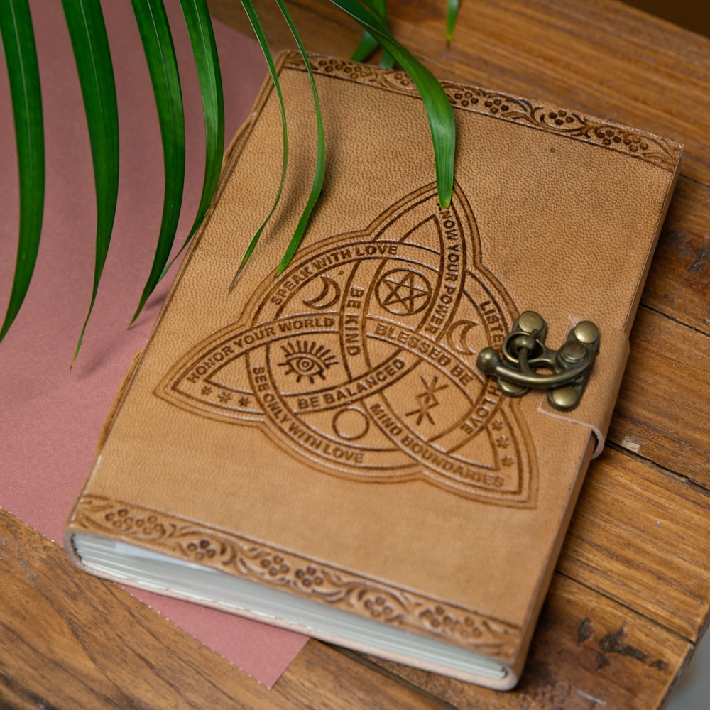 spiritueel notitieboek met positieve teksten op houten tafeltje